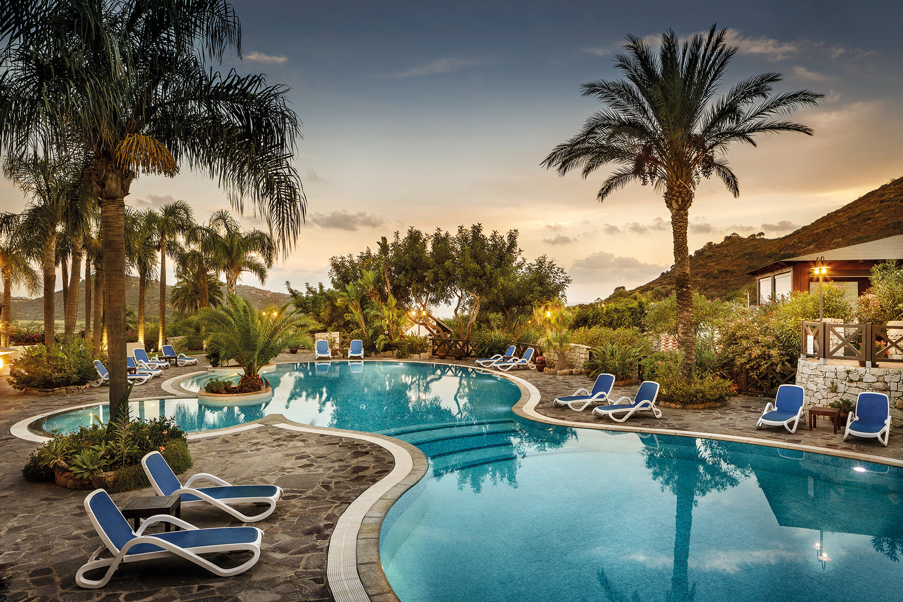 Mit Palmen gesäumter Pool im Hotel Cruccuris Resort